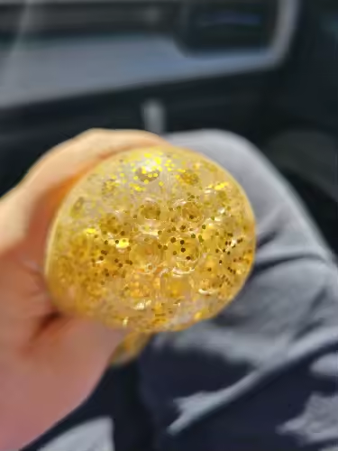 Gold glitter squishy squeezed in a car